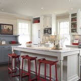 netral kitchen with red barstools and red accents